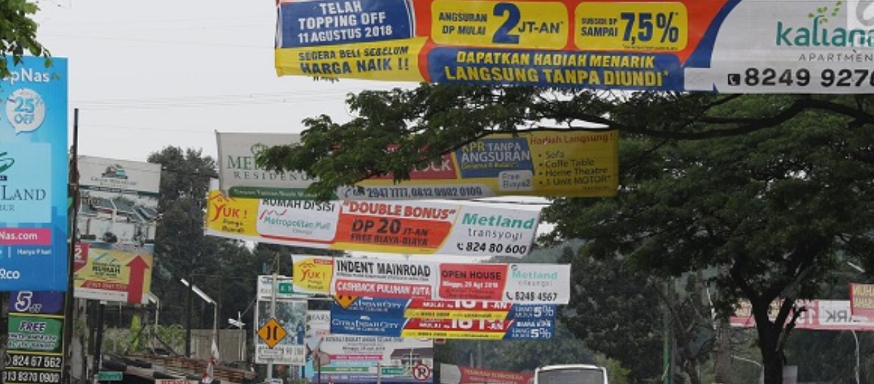 spanduk merupakan contoh iklan media cetak yang sering di pasang dijalan raya.